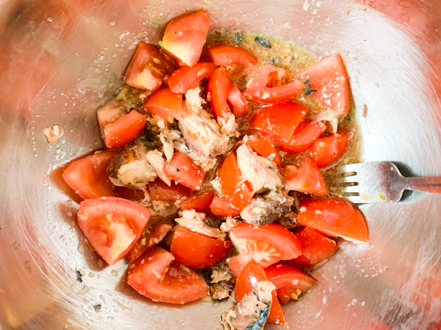 乱切りにしたトマトと、おろしニンニク、ポン酢投入して、しっかり混ぜ合わせます。