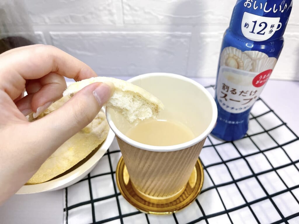 リケン「割るだけスープ」ホタテチャウダーと、小さくちぎったパンを手に持って紹介する画像