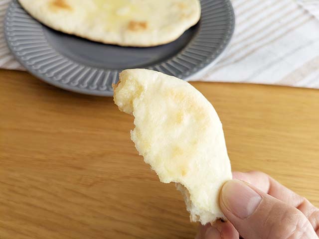 焼きあがったナンを指でつまんでいる様子