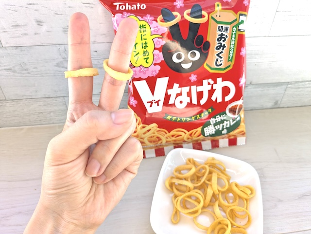 東ハト『Ｖなげわ 自分に勝ツカレー味』指に嵌めてVサイン