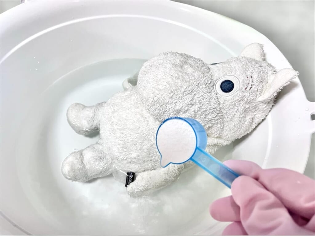 ぬいぐるみ・ムーミンを入れたランドリーバケツで「オキシクリーン」の溶液を作る様子