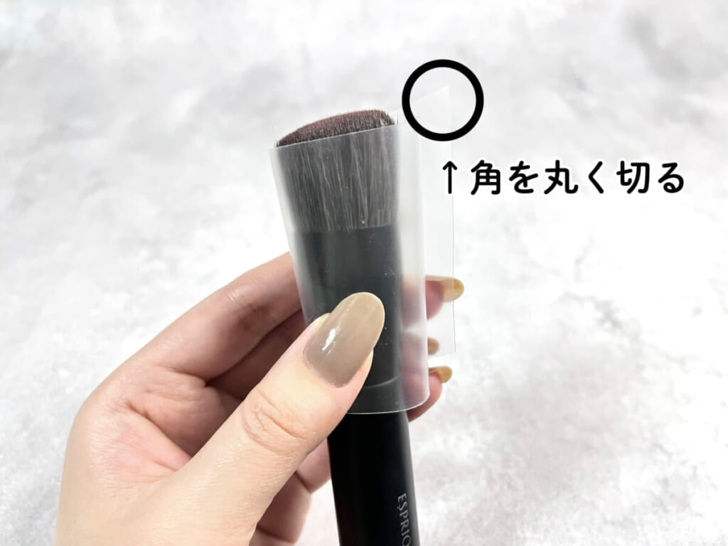 細長く切ったクリアファイルをメイクブラシに巻いた様子