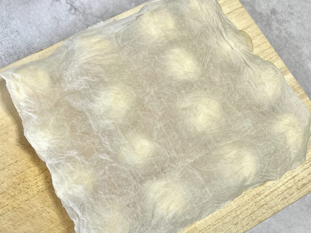 まな板の上にのせた「ちぎりパン」の生地に濡らしたキッチンペーパーを被せ、二次発酵させている様子