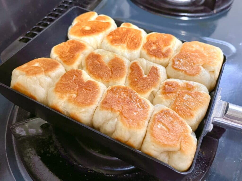 卵焼き器で「ちぎりパン」の生地を焼き、裏返して焼き色をつけている様子