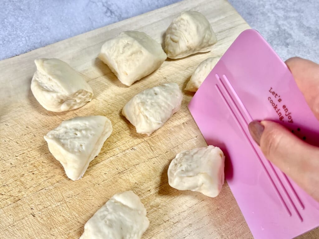 まな板の上にのせた「ちぎりパン」の生地をスケッパーで16等分にしている様子