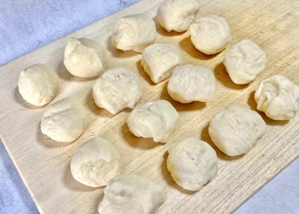 まな板の上にのせた「ちぎりパン」の生地をスケッパーで16等分にした様子