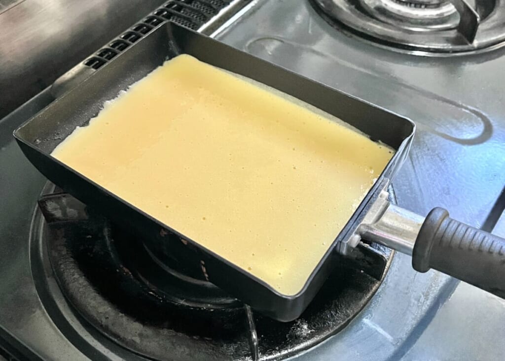 「いちごのキャンドルケーキ」の生地を卵焼き器に流し入れ、焼いている様子