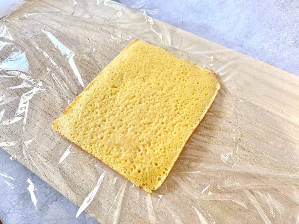 まな板の上にキッチンラップを敷き、「いちごのキャンドルケーキ」の生地の粗熱をとっている様子