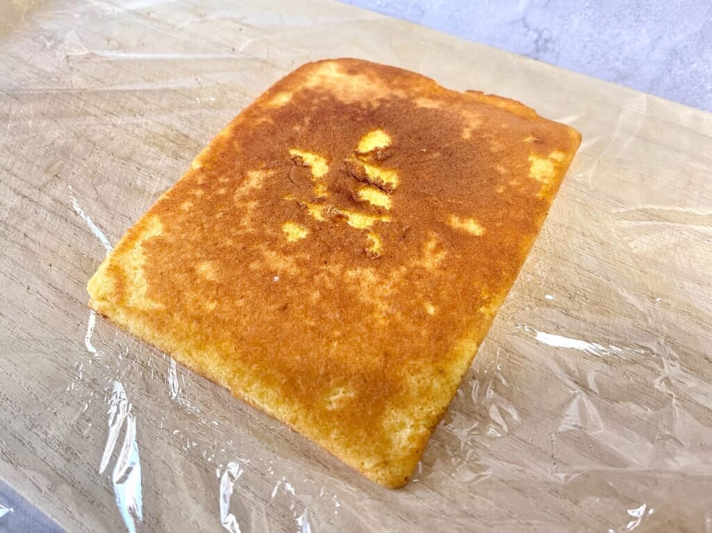 まな板の上にキッチンラップを敷き、「いちごのキャンドルケーキ」の生地を裏返した様子