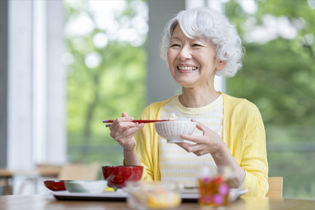 笑顔でご飯を食べる女性